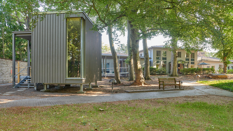 Der über einen Steg zugänglich Raum der Stille unter hohen Bäumen im Außenbereich des Stationären Diakonie Hospiz Wannsee in Berlin-Wannsee. Der über einen Steg zugänglich Raum der Stille unter hohen Bäumen im Außenbereich des Stationären Diakonie Hospiz Wannsee in Berlin-Wannsee.