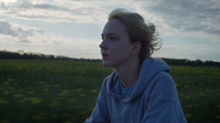 Filmausschnitt aus dem Kinofilm "Sechswochenamt" mit einer Frau vor einem mit Gras bewachsenen Hügel und einem Himmel mit Wolken. Filmausschnitt aus dem Kinofilm "Sechswochenamt" mit einer Frau vor einem mit Gras bewachsenen Hügel und einem Himmel mit Wolken.