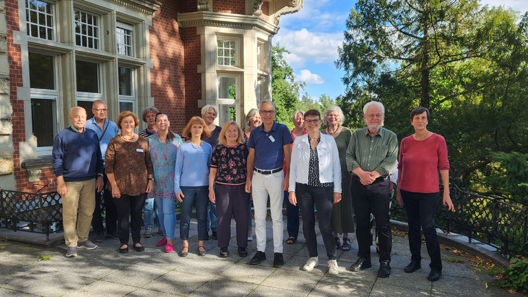 Gruppenfoto im Park der Siemens-Villa der Immanuel Albertinen Diakonie in Berlin-Wannsee mit ehrenamtlichen Mitarbeitenden und hauptamtlichen Koordinatorinnen und Koordinatoren des Hospiz- und Palliativberatungsdienstes im Diakonie Hospiz Wannsee