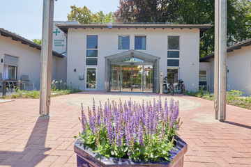 Blick auf den Eingangsbereich mit einem großen Pflanzgefäß mit Lavendelblüten vor dem Eingang das Stationären Diakonie Hospiz Wannsee in Berlin-Wannsee. Blick auf den Eingangsbereich mit einem großen Pflanzgefäß mit Lavendelblüten vor dem Eingang das Stationären Diakonie Hospiz Wannsee in Berlin-Wannsee.