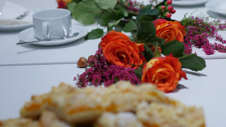 Gedeckte Tafel mit Blumen, Kuchen und Kaffeetassen  - Trauercafe - Diakonie Hospiz Wannsee