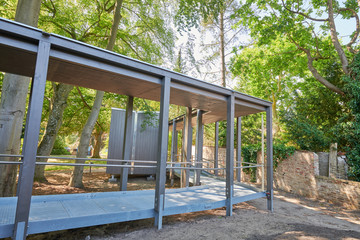 Der überdachte Steg zum Raum der Stelle auf dem mit Bäumen und Pflanzen bewachsenen Außengelände des Stationären Diakonie Hospiz Wannsee in Berlin-Wannsee. Der überdachte Steg zum Raum der Stelle auf dem mit Bäumen und Pflanzen bewachsenen Außengelände des Stationären Diakonie Hospiz Wannsee in Berlin-Wannsee.